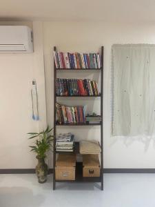 een boekenplank gevuld met dvd's in een kamer bij Aiem-Wilai Guesthouse in Suratthani
