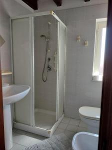 ein Bad mit einer Dusche, einem WC und einem Waschbecken in der Unterkunft La Casa Rossa in Riola Sardo
