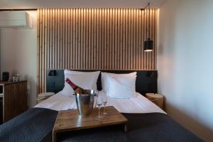 ein Hotelzimmer mit einem Bett mit einem Tisch und Weingläsern in der Unterkunft Haltia Lake Lodge nature boutique hotel & glamping in Espoo