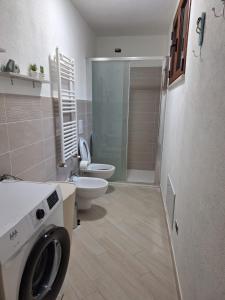 Un baño con inodoro y lavadora. en Casa NOAH, en Teulada