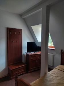 a bedroom with a bed and a cabinet and a window at Pałac Chojnata in Wola Chojnata