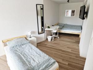 a bedroom with two beds and a mirror at Pension Weserufer in Brake