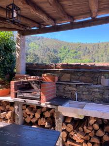 a outdoor kitchen with a pile of fire wood at Casa da Carolina in Lousã