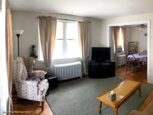 una sala de estar con un sofá y una mesa en Bryn Mawr Guest Suites, en Bryn Mawr