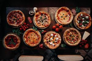 a group of pizzas on a wooden table at Fontinha Porto, Trademark Collection by Wyndham in Porto