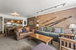 un soggiorno con divani e un muro di mattoni di PARK STATION 121 condo a Park City