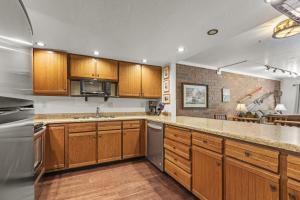 una cucina con armadietti in legno ed elettrodomestici in acciaio inossidabile di PARK STATION 121 condo a Park City Altre 24 foto