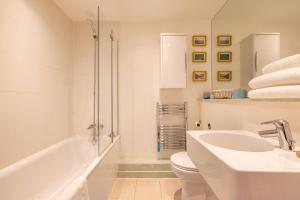 a bathroom with a sink and a toilet and a tub at Wild Roses Serviced Apartments - City Airport in North Woolwich +29 photos