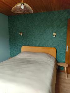 a bedroom with a bed and a green wall at Villa Monette -Le Crotoy in Le Crotoy