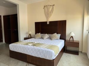 a bedroom with a large bed with a wooden headboard at Nabani Condominios T2 in Santa Cruz Huatulco +25 photos