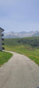 an empty road in the middle of a field at Appartement montagne in Superbagnères