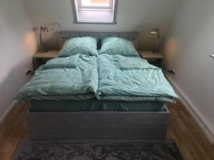a bed with green comforter in a bedroom at Ferienhaus Hahndorf in Goslar