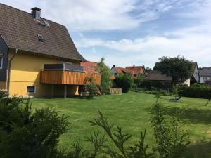 a house with a green yard with houses in the background at Ferienhaus Hahndorf in Goslar