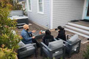 un gruppo di persone seduti intorno a un tavolo su un patio di Good Day Getaway by Seabrook Hospitality a Pacific Beach