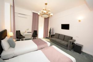 Habitación de hotel con 2 camas y sofá en Hotel Andre´s, en Craiova