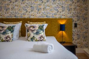 een bed met een witte handdoek erop bij Hotel Onderbergen in Gent