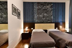 duas camas num quarto com duas camas sidx sidx sidx em B&B Donna Eleonora em Matera