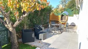 MontbazinにあるLe loftの木の下にテーブルと椅子のあるパティオ
