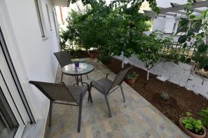 a patio with a table and chairs and plants at Magenta in Igoumenitsa