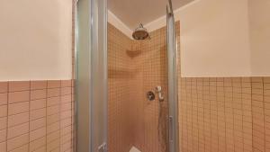 un bagno con doccia con porta in vetro di Villa Caburlotto a Grado Altre 32 foto