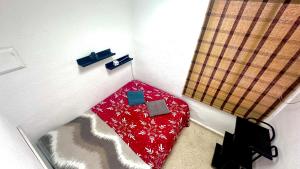 a small room with a red bed in a room at Las habitaciones de Svetlana in Alicante