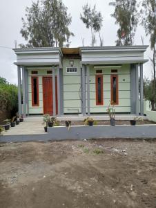 a small green house with a red door at Mentigen Homestay in Ngadisari