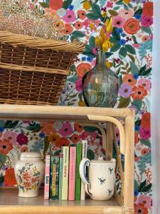 une étagère avec un vase, des livres et un panier dans l'établissement Gite Bulle Appart' 1, à Épernay