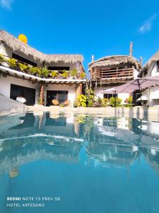 a pool of water in front of a house at Arte Sano Hotel - Adults only in Holbox Island