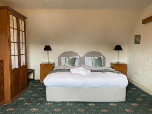 a bedroom with a large white bed with green pillows at Garden Park Guest House in Grantown on Spey