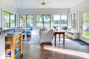 a kitchen with a table and chairs and windows at Waterfront Cottage in Summer Village with Grill in Westford