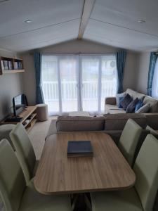 a living room with a table and a couch at Golf and Leisure Retreat in Great Yarmouth