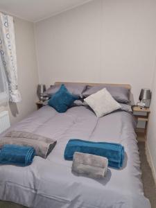 a bed with three pillows on top of it at Golf and Leisure Retreat in Great Yarmouth +11 photos