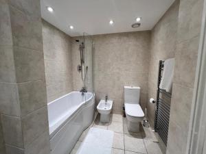 倫敦的住宿－Mayfair Piccadilly Apartment 5，带浴缸、卫生间和盥洗盆的浴室