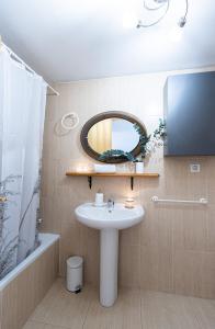 W łazience znajduje się umywalka i lustro. w obiekcie Apartamento familiar Canfranc Estación w mieście Canfranc-Estación