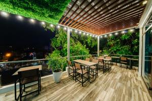 a patio with tables and chairs on a balcony at Su Casa Hanoi Old Quarter in Hanoi