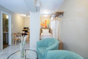 a living room with a blue chair and a table at Athina résidence in Nydri