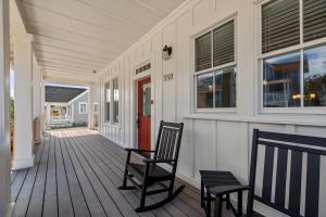a porch with two chairs and a red door at Happy to Sea You by Seabrook Hospitality in Pacific Beach