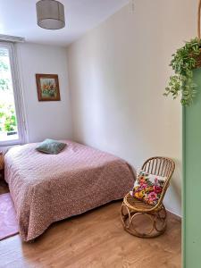 a bedroom with a bed and a chair at Gite Bulle Appart' 1 in Épernay