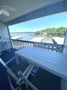 a table on a balcony with a view of a river at B Lakefront! Remodeled, Boat Slip, Patio Views, Pool, Boat Ramp, WIFI in Osage Beach