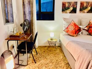 um quarto com uma secretária, uma cama e uma mesa em Skyfly Bed & Breakfast em Manzini