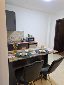 een keuken met een aanrecht met 2 stoelen en een tafel bij New House Kobuleti 2 in Kobuleti