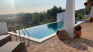 a swimming pool with a view of a house at Monte Das Aguas Frias in Rosário +13 photos