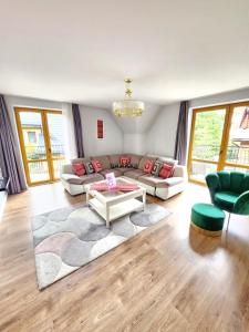 a living room with a couch and a table at Bory6a Apartamenty & Free Parking in Zakopane +153 photos