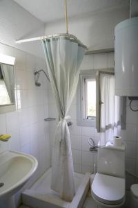 a white bathroom with a sink and a toilet at Olive Summer House in Chrysi Ammoudia