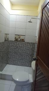 a bathroom with a toilet and a shower at El Jardín de la Bella in Tingo María