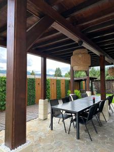 a patio with a table and chairs under a wooden pergola at Casa Davideea in Colibiţa