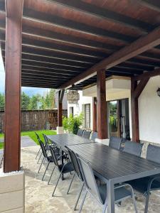 a wooden table and chairs under a wooden pergola at Casa Davideea in Colibiţa