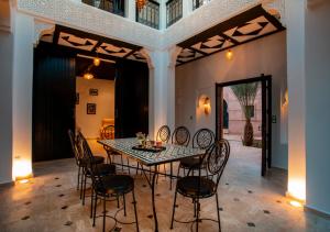 uma sala de jantar com mesa e cadeiras em Riad Tamazgha em Marrakech