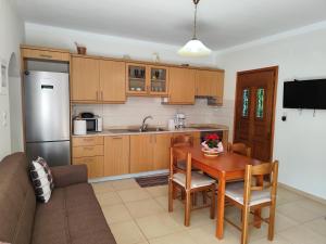 a kitchen with a table and a kitchen with a couch at Garden Home in Panormos Kalymnos