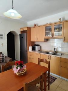a kitchen with a wooden table and a dining room at Garden Home in Panormos Kalymnos